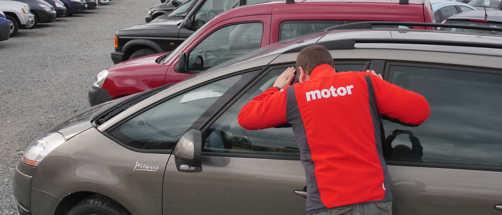 Człowiek ogląda auto w komisie