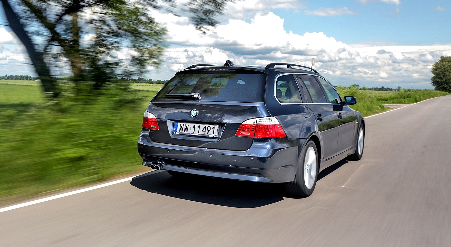 BMW 530i Touring E61 w ruchu na drodze poza miastem tył i bok