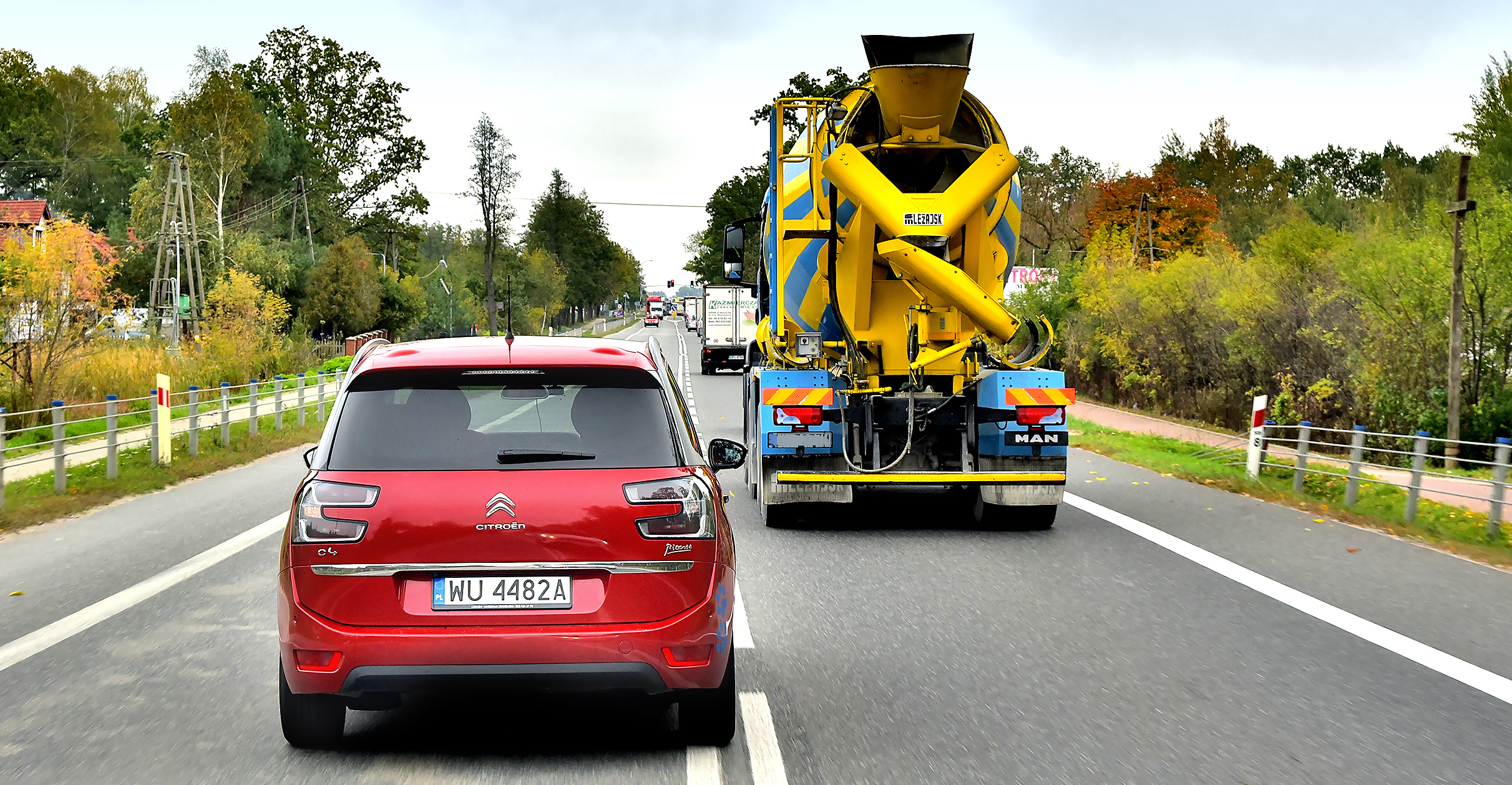 Citroen wyprzedza ciężarówkę na drodze jednopasmowej