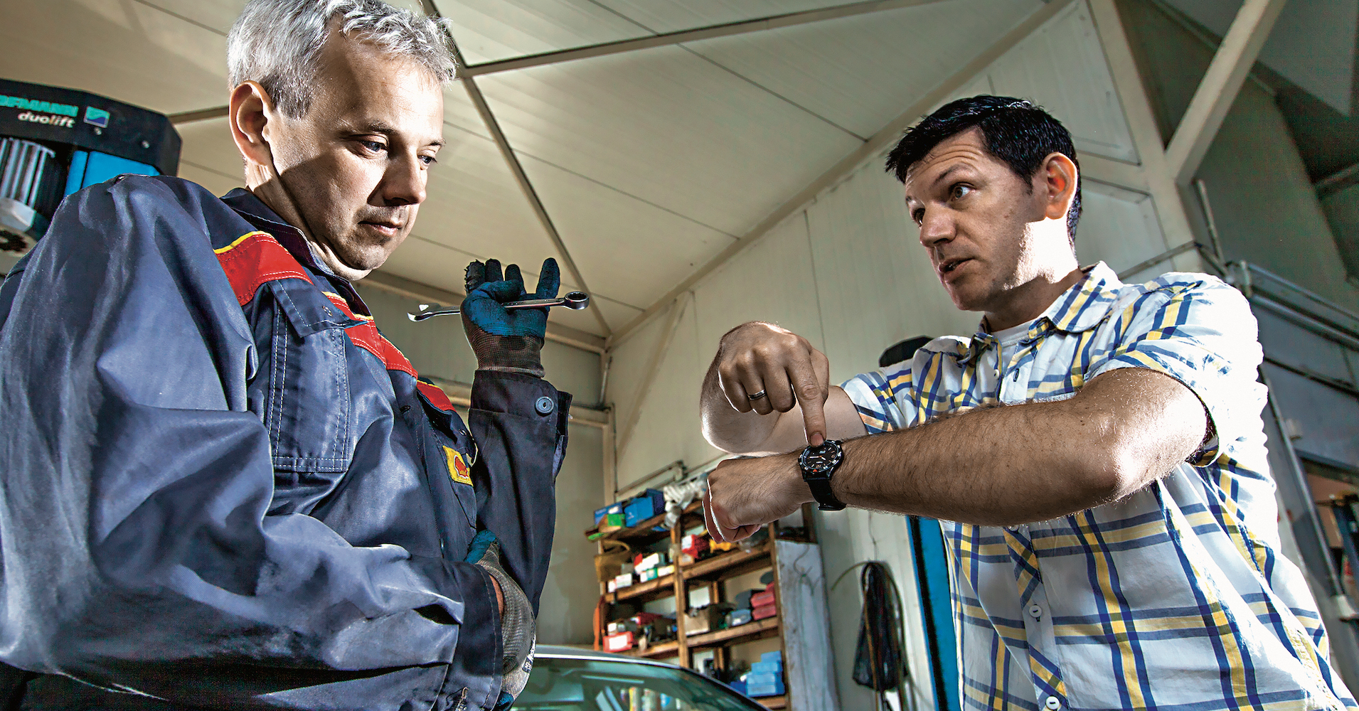 klient pokazuje na zegarek mechanikowi