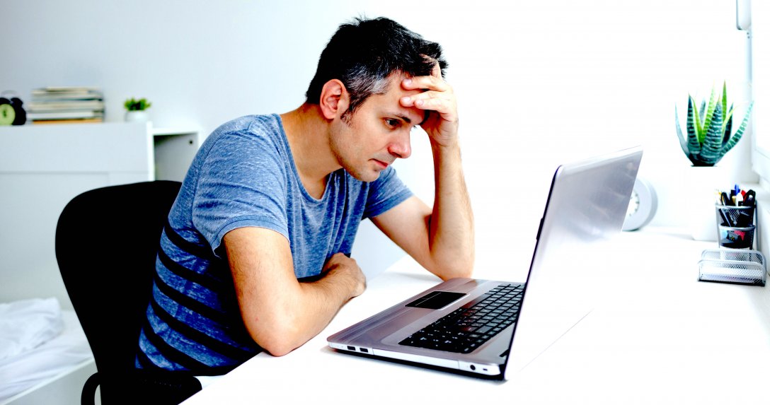 Człowiek patrzy smutny na laptop