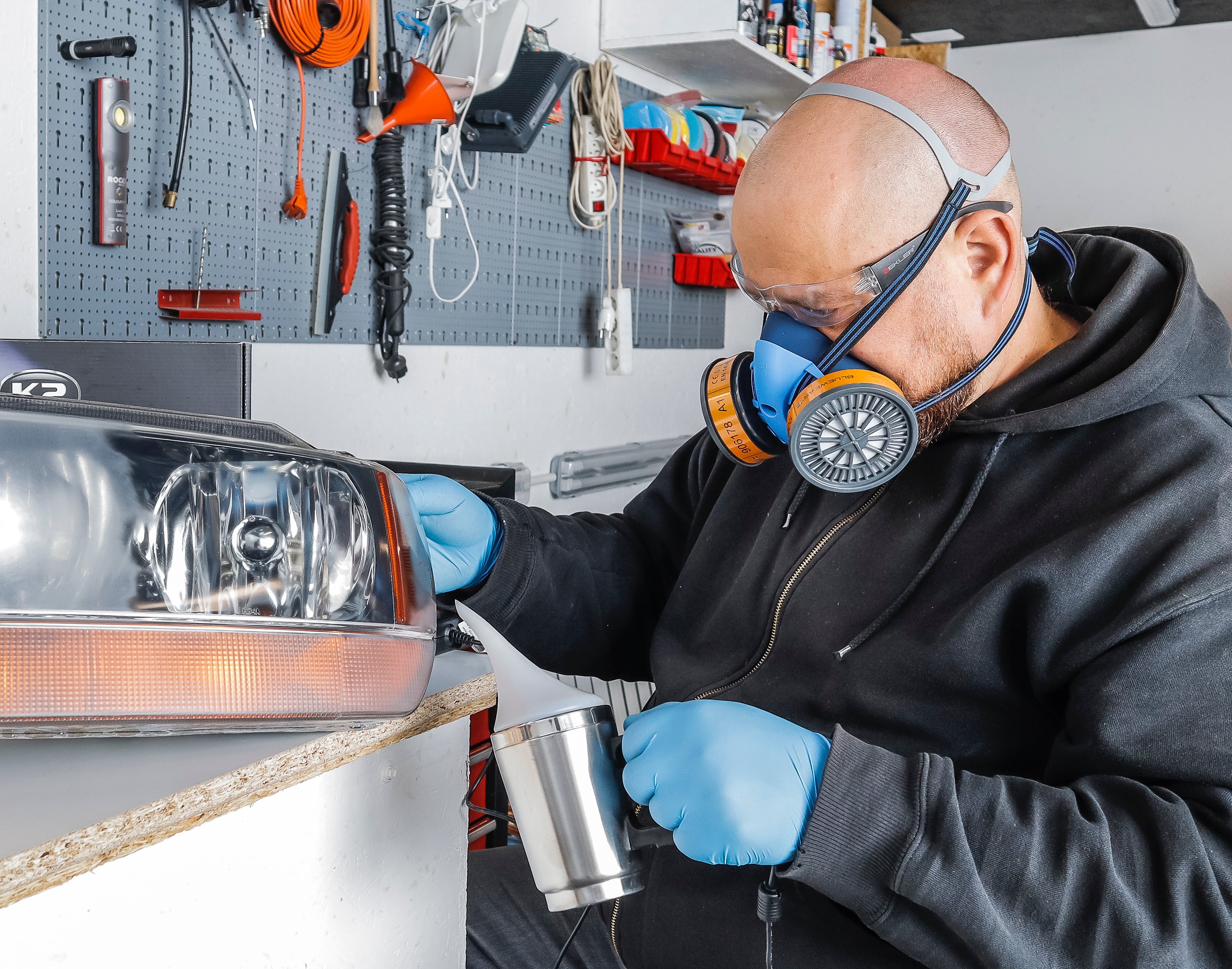 mężczyzna w masce fitrującej i rekawiczkach podczas regenracji reflektora