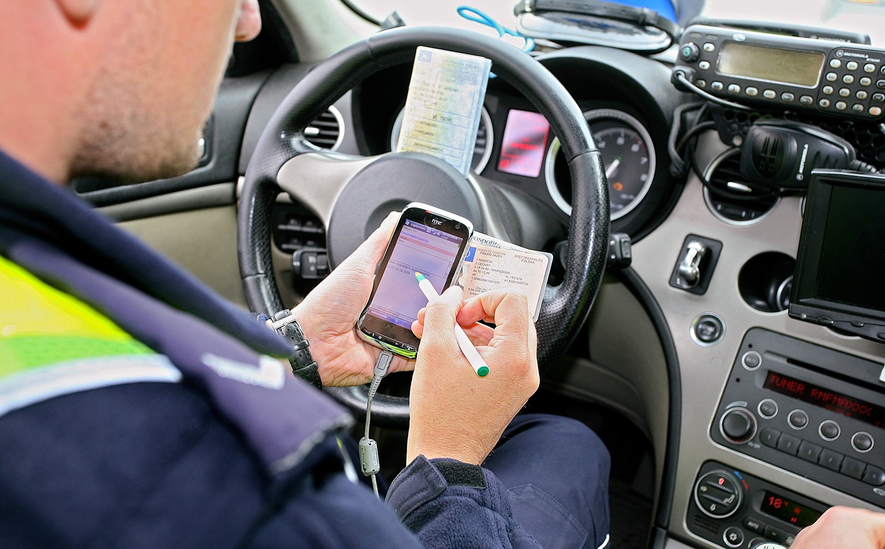 policjant sprawdza dokumenty w komputerze