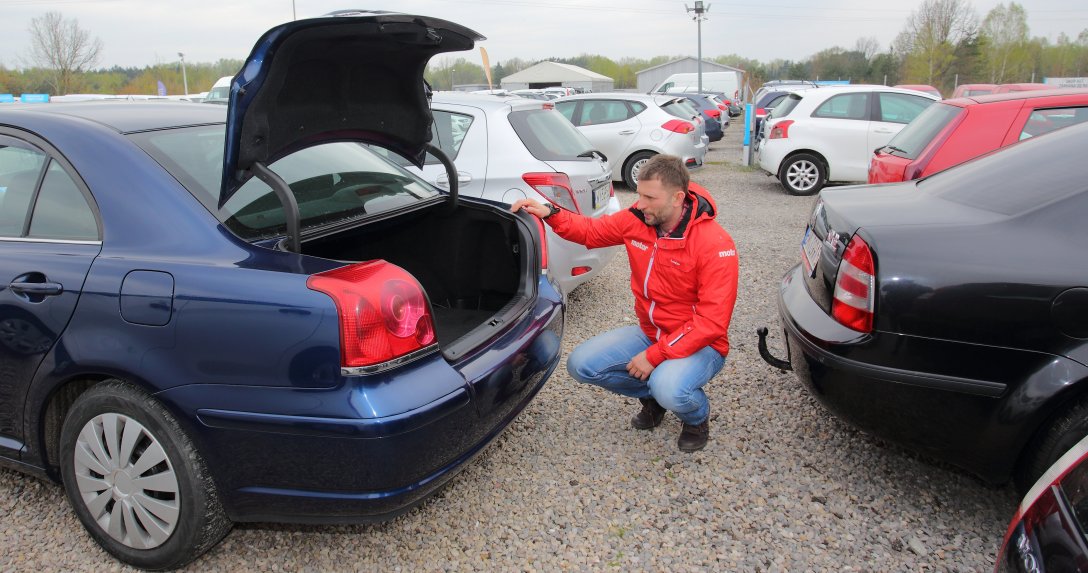 mężczyzna ogląda bagażnik samochodu