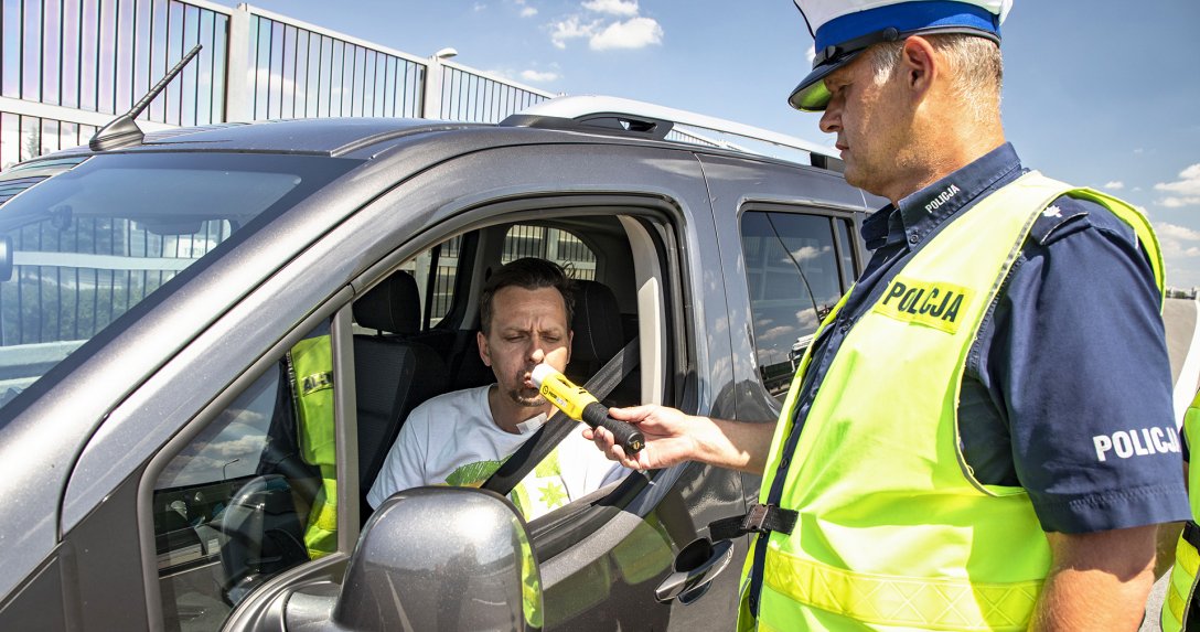 policjant kontroluje kierowcę alkomatem