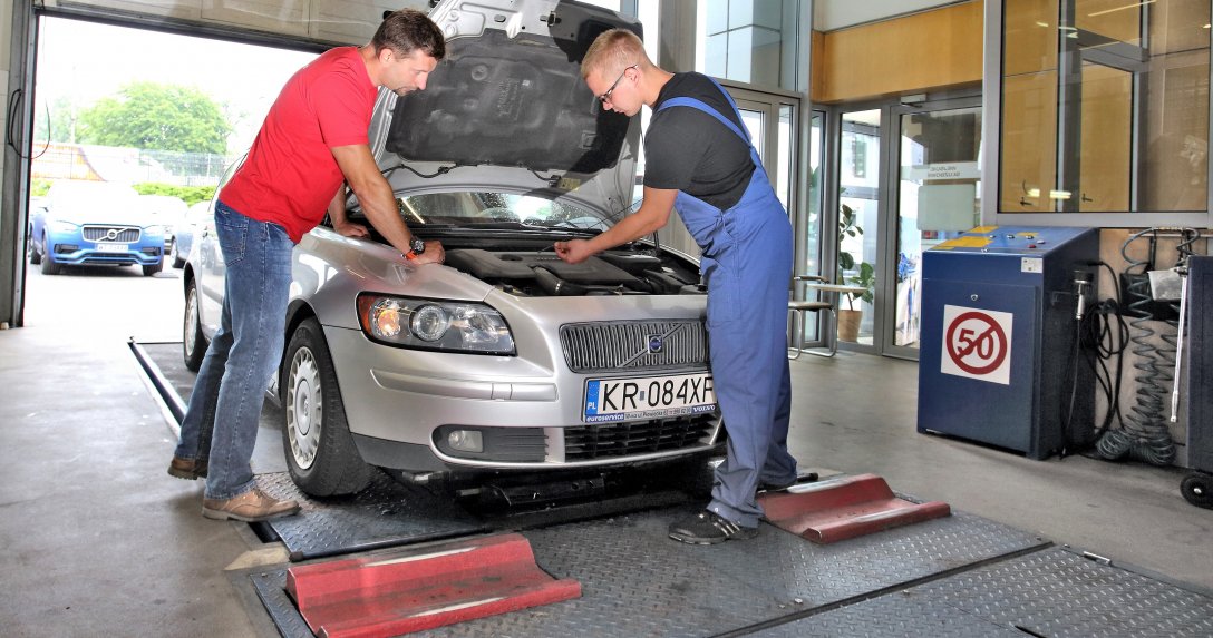 Kierowca i mechanik rozmawiają przy aucie
