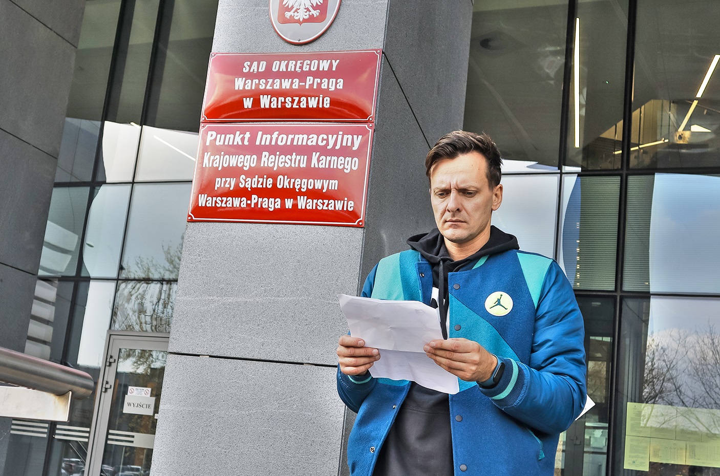 mężczyzna wychodzi z dokumentami z sądu