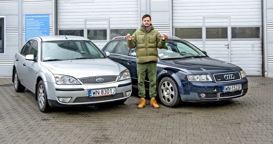 Ford Mondeo i Audi A4 zaparkowane przed garażem z mężczyzną stojącym między nimi