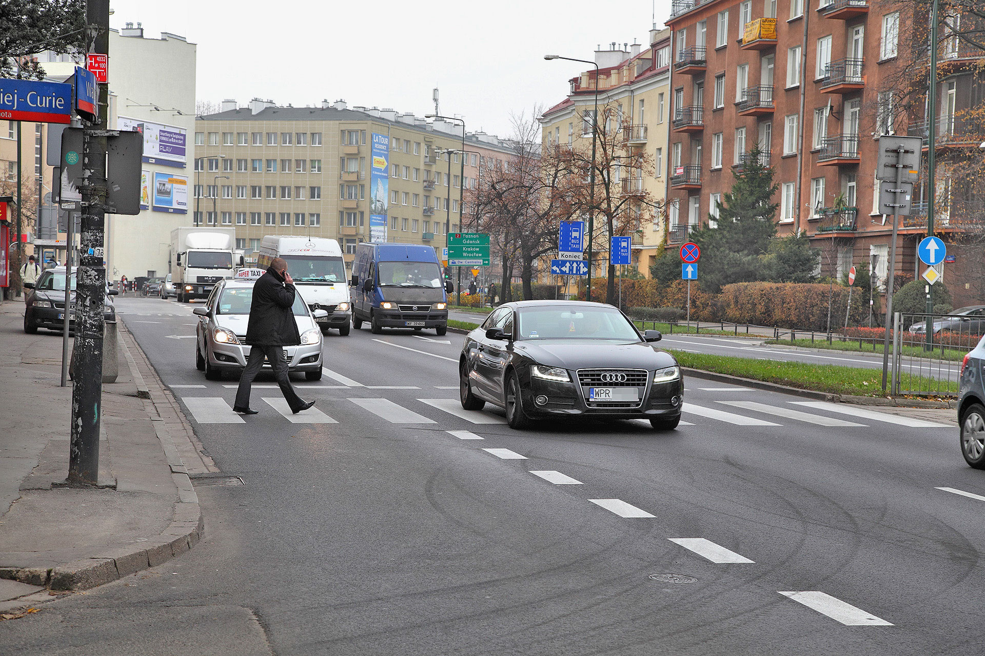 pieszy idący po przejściu i rozmawiający przez telefon