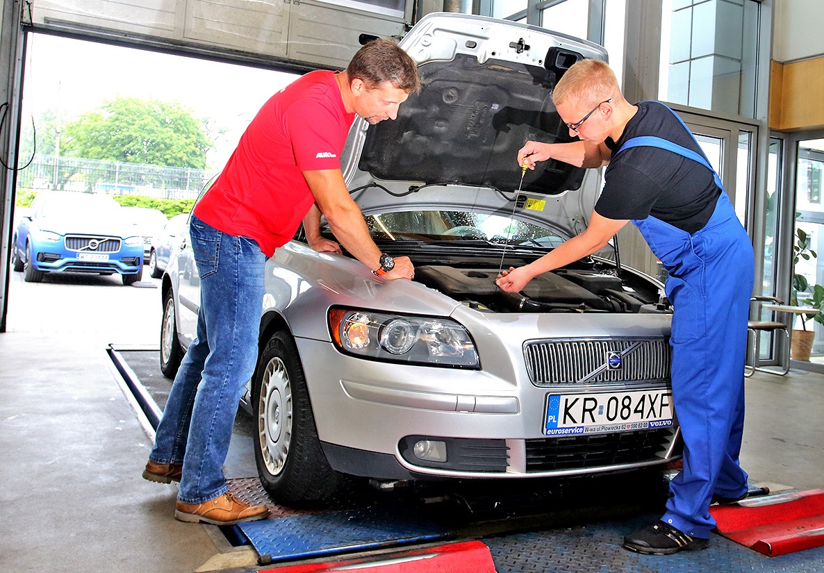 dwie osoby przy aucie w seriwsie