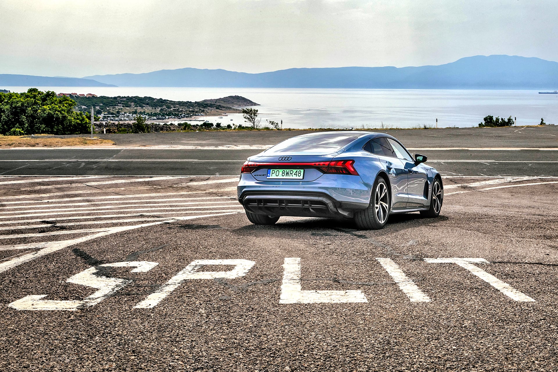 Audi e-tron GT quattro tył i bok – na drodze za napisem Split na nawierzchni