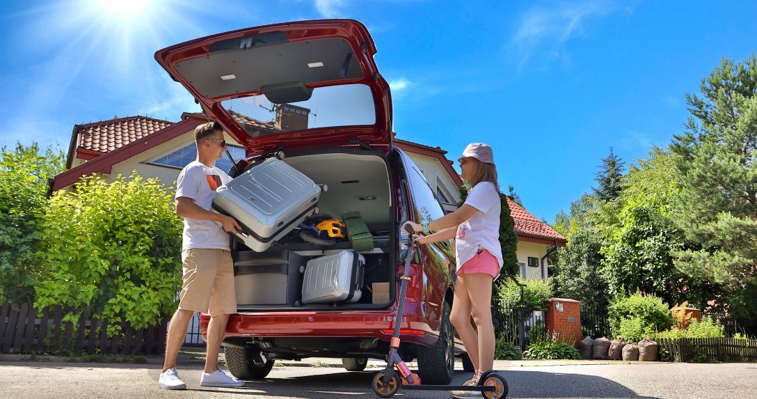 rodzina wyjeżdżająca na wakacje pakuje bagaże do samochodu