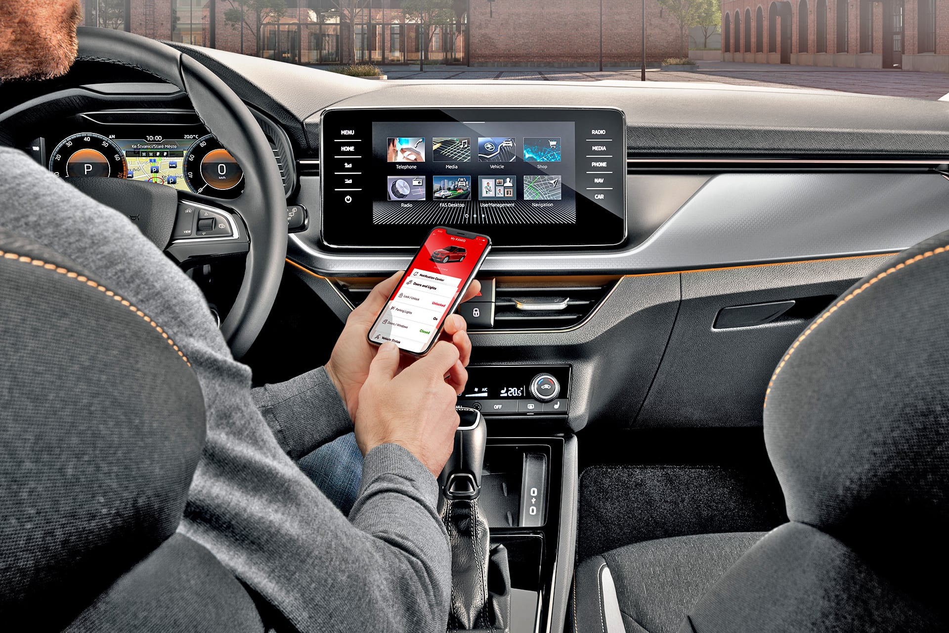 Skoda - deska rozdzielcza i mężczyzna za kierownicą używający aplikacji na telefonie