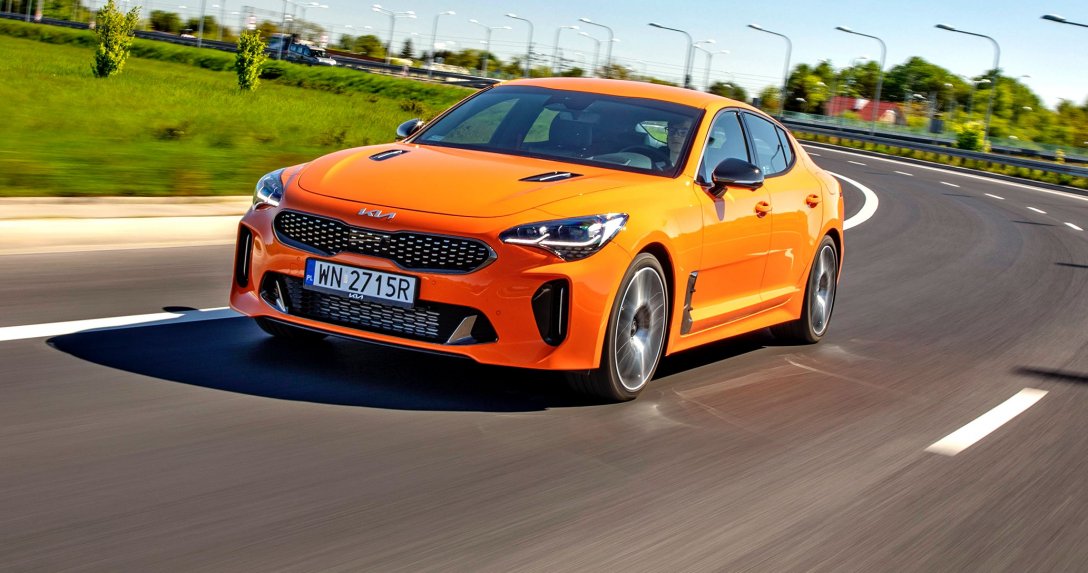 Kia Stinger 3.3 V6 T-GDI 8AT AWD GT – przód i bok w ruchu na łuku drogi