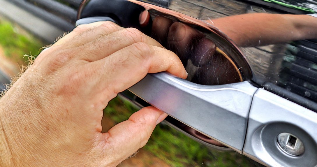 Otwieranie auta – ręka chwytająca za klamkę