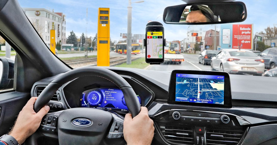 Smartfon z aplikacją na szybie przed fotoradarem