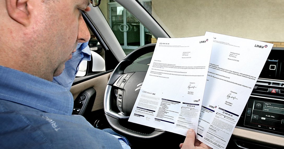 Kierowca czyta zapisy umowy ubezpieczeniowej