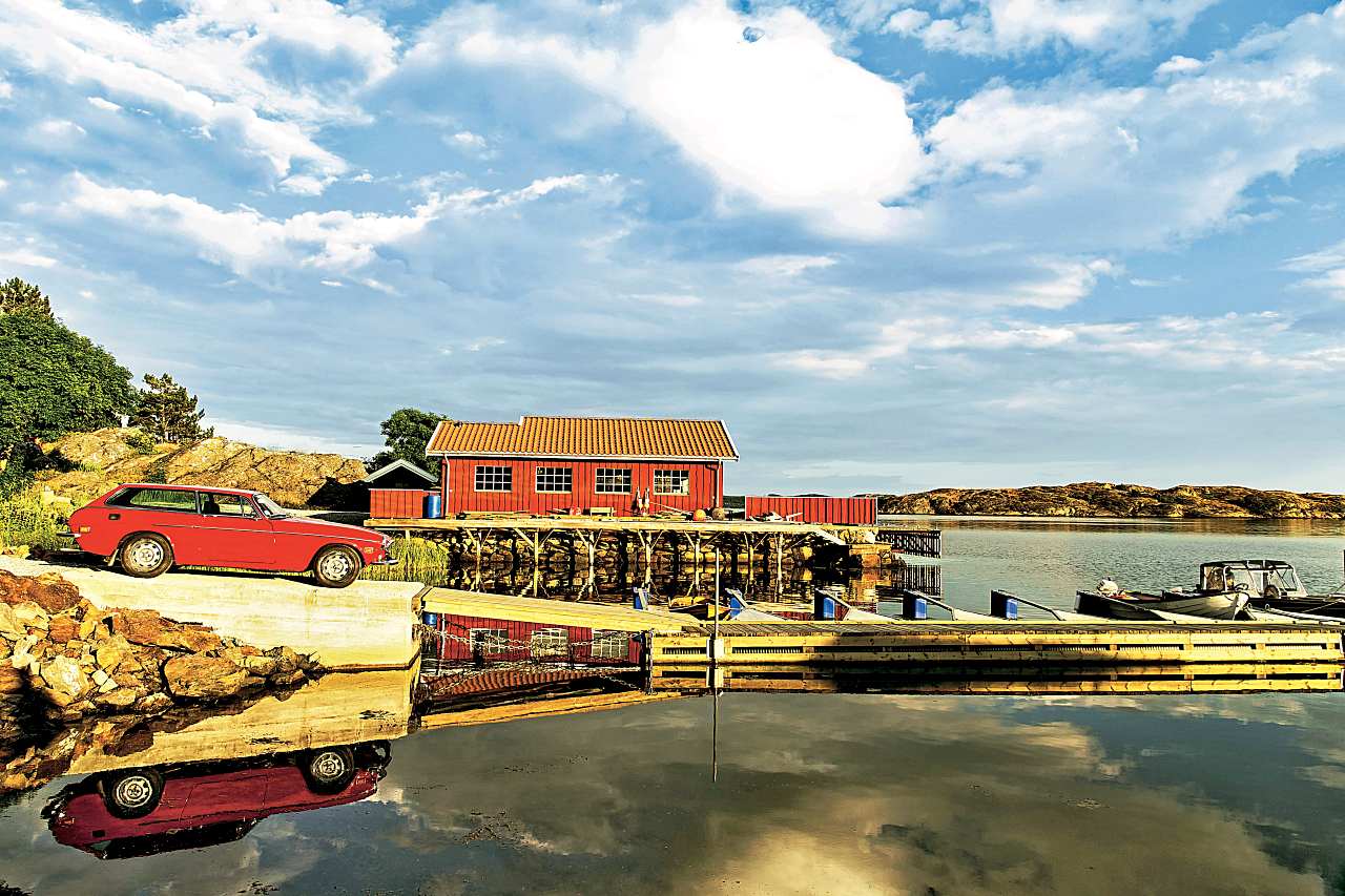 Volvo-1800-ES-bok-ze szwedzkim-krajobrazem-w-tle