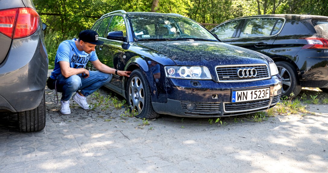 Mężczyzna ogląda zapuszczone auto