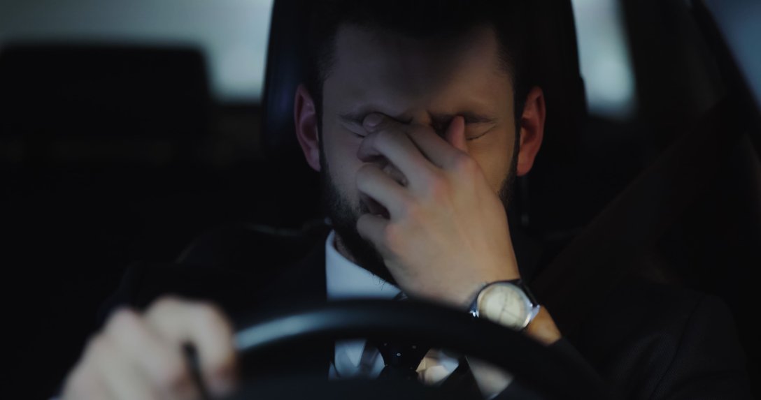 mężczyzna ze złym samopoczuciem za kierownicą