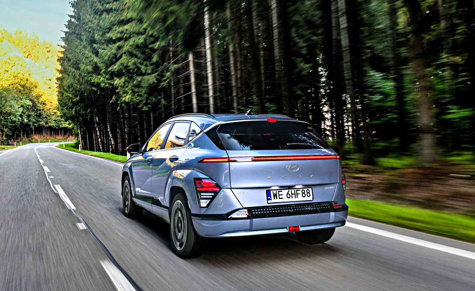 hyundai kona – widok z tyłu podczas jazdy asfaltową droga w lesie