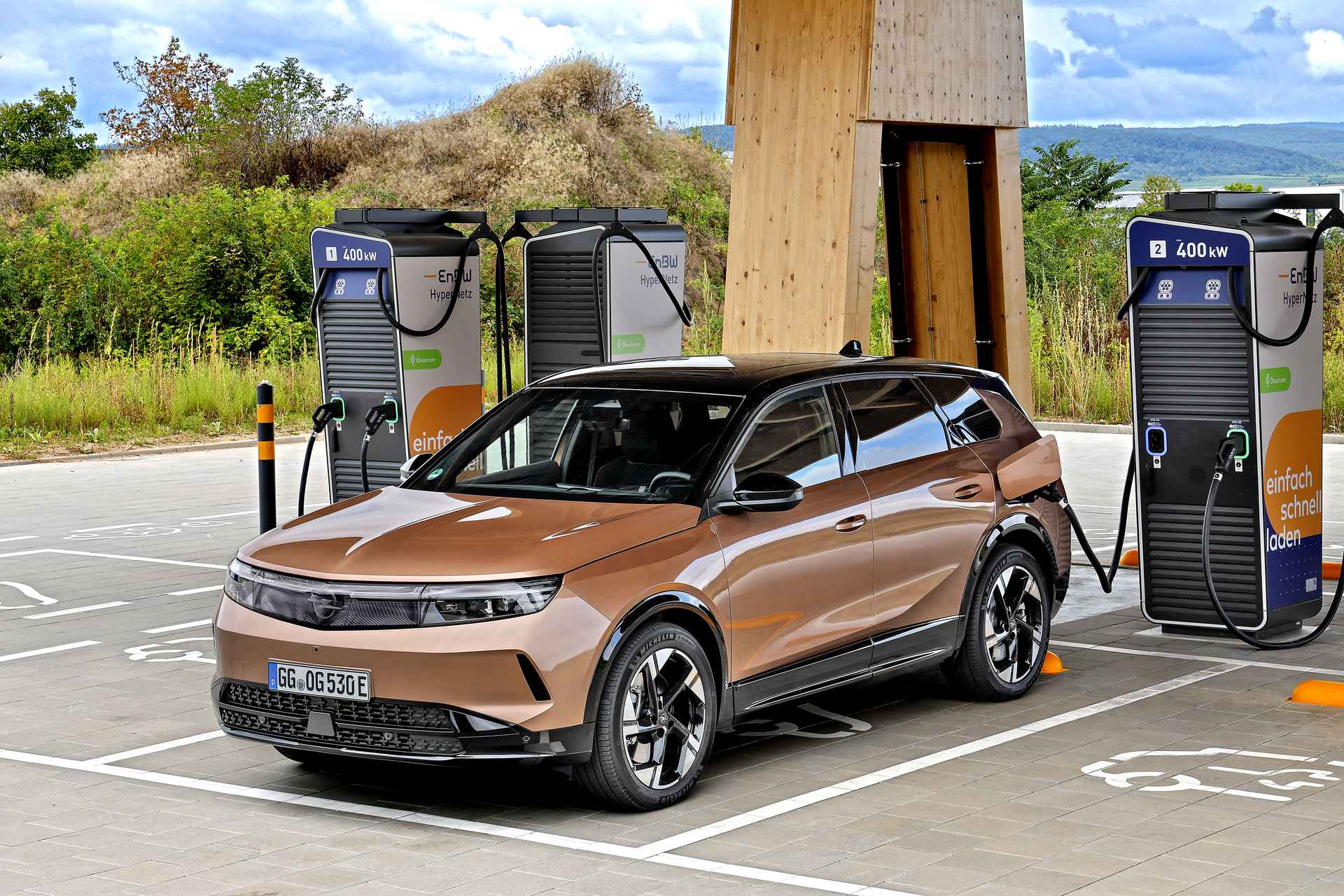 Opel Grandland Electric przy stacji szybkiego ładowania.